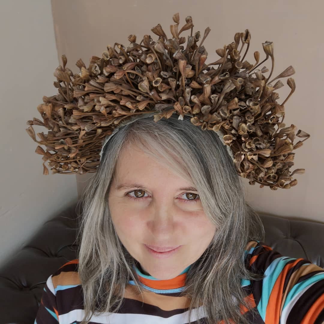 Bet wearing a sculptural headpiece made from dried botanicals
