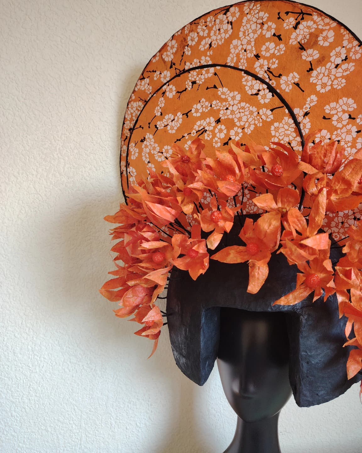 Orange botanical headpiece with graphic circular forms